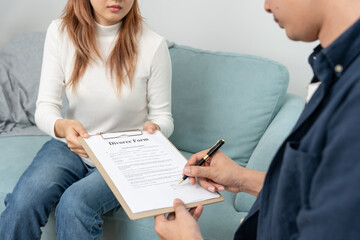 Divorce. man review and sign Divorce form. Couples desperate and disappointed after marriage. wife...