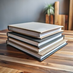 Fototapeta premium Stack of four hardcover books on a wooden table.