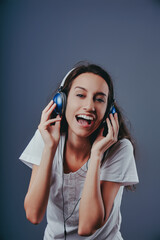 Young woman singing while listening to music on headphones