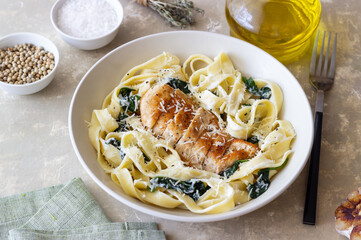 Pasta alfredo with chicken, spinach and cheese. Italian food.