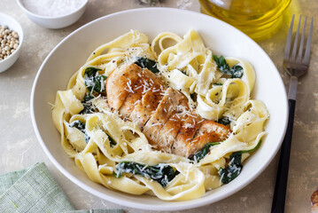 Pasta alfredo with chicken, spinach and cheese. Italian food.