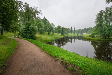 A path leads to a pond with a bridge over it