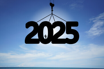 Concept Happy new year Silhouette of 2025 lifting crane with engineer standing by to supervise the work on blue sky background.
