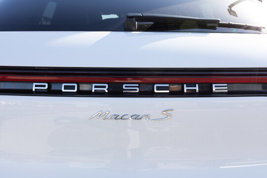 Beaverton, Oregon, USA - March 7, 2024 - White Porsche Macan S car parked in a parking lot, close up logo. High quality picture for download