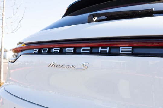 Beaverton, Oregon, USA - March 7, 2024 - White Porsche Macan S car parked in a parking lot, close up logo. High quality picture for download