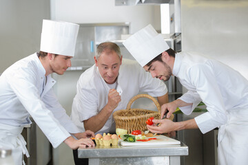 chefs watching trainee prep vegetables