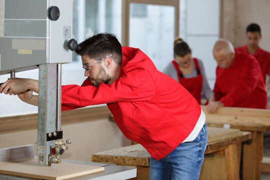 young man setting up woodworking machine