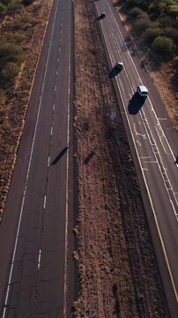 Vertical Aerial View of Traffic on Arizona State Route at Sunset, Landscape, Cars and Cracked Asphalt, Revealing Drone Shot