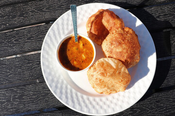 Indian cuisine - Puri Bhaji. It is a traditional breakfast dish in North India. Puri is a deep fried bread made from whole wheat flour and Served with spicy Potato curry called bhaji or alu ki sabji.
