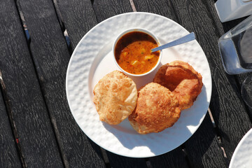 Indian cuisine - Puri Bhaji. It is a traditional breakfast dish in North India. Puri is a deep fried bread made from whole wheat flour and Served with spicy Potato curry called bhaji or alu ki sabji.