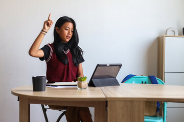 Portrait Of Young Student Girl Wearing School Uniform Studying At Home Using Digital Tablet 