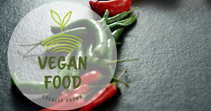 Vegan food logo animation over fresh green and red chili peppers