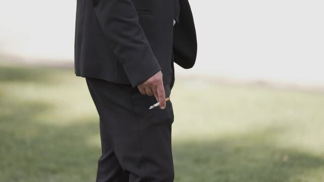 Man in a suit holding a cigarette outdoors, highlighting smoking and health concerns
