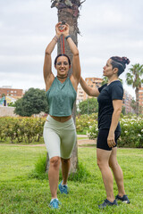 Women performing strength exercises outdoors