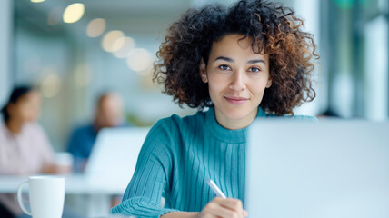 Focused woman working on laptop at modern office. Professional and confident, she exemplifies productivity and dedication in a corporate environment.