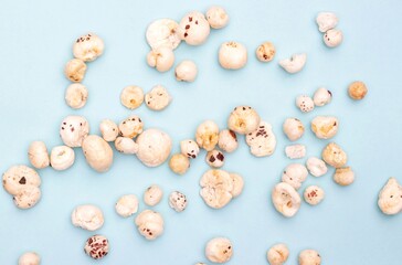 Makhana or Fox Nut Scattered on Light Blue Background with Copy Space, Also Known as Lotus Seed Pop, Euryale Ferox or Gorgon Nut
