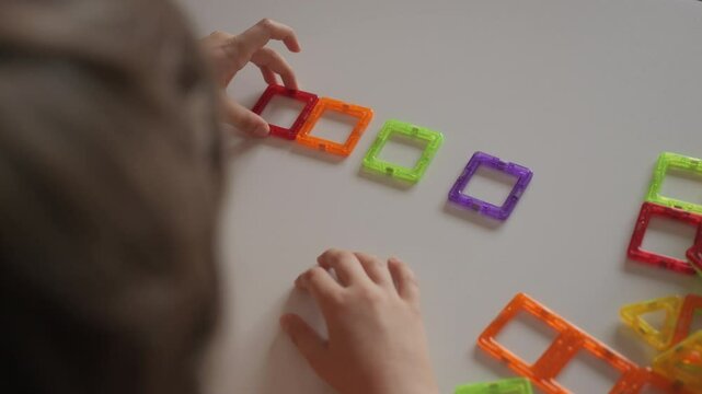 Magnetic Force Demonstration Showing Attraction. Boy Playing With Magnetic Tiles Stacking Blocks Game Set Toy. Development of Attention and Imagination. Creativity and Learning in Childhood.