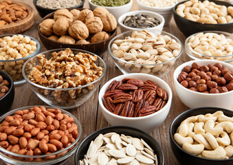 Mixed raw nuts and seeds in bowls on kitchen table.Peanut,hazelnut,walnut,almonds,pistachio,sunflower,pumpkin,chia and cashew.Macro