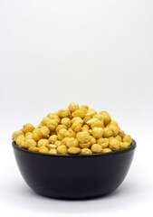 Closeup of Roasted Chickpea or Garbanzo Bean in a Black Bowl Isolated on White Background with Copy Space, Also Known as Bengal Gram or Egyptian Pea