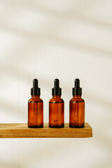 Collection of Amber Glass Dropper Bottles Displayed on a Minimalist White Surface in Natural Light