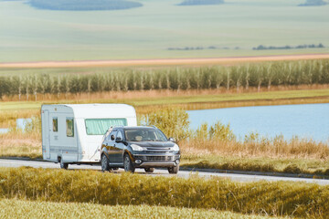Car pulling trailer along scenic route