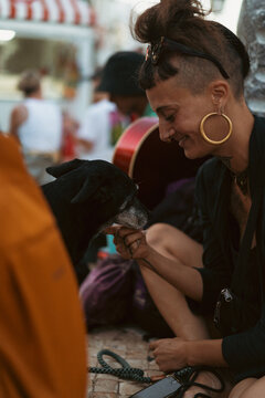 Informal, bright appearance, young woman with a dog on the street.