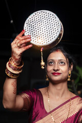 An Indian woman is looking at the moon through a sieve during the Karwa Chauth festival.