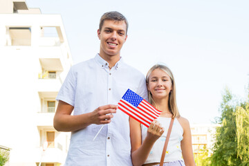 Happy beautiful teenagers students with US flag. Brother and sister study abroad, learn English in USA. American life and education.