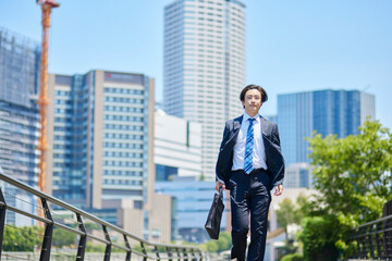 ビジネス街を歩くスーツを着た若いビジネスマン