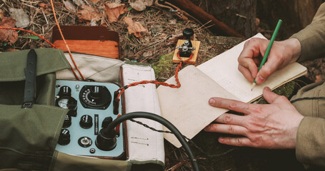 Russian Soviet Infantry Red Army Soldier In World War II using Russian Soviet Portable Radio Transceiver In Trench Entrenchment In Spring Autumn Forest. . Headphones And Telegraph Key. Close Up Hands © Great Brut Here
