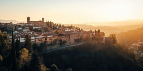 Naklejka premium Sunset over spanish hilltop cityscape with historic architecture and lush landscape