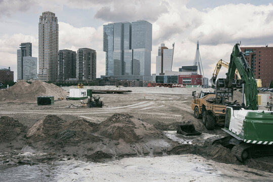 A dynamic scene of a construction site, with machinery and earth-moving equipment, set against the backdrop of a modern city skyline featuring high-rise buildings in Rotterdam