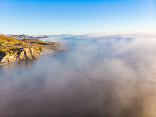 Sea with morning fog over water.