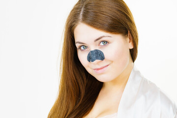 Woman applying pore strips on nose
