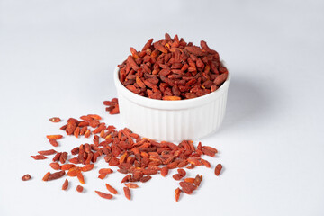 Dried Goji berries in a plate on a white background