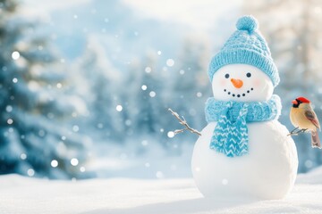 Fototapeta premium Snowman wearing blue hat and scarf, standing in a snowy field with snow-covered mountains in the background.