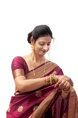 A joyful Hindu Indian woman from India dressed in a traditional saree is adjusting her clothing.