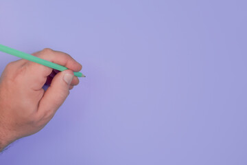 Pencil handwriting on purple background by a man copy space