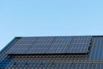 Fototapeta premium solar panels on home roof against blue sky