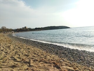 Serene Pebble Beach at Sunset with Gentle Waves and Tranquil Horizon