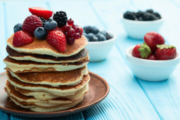Stack of homemade american pancakes with berries . Top view