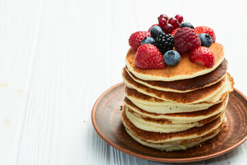 Stack of homemade american pancakes with berries . Top view