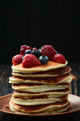 Stack of homemade american pancakes with berries . Top view
