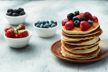 Stack of homemade american pancakes with berries . Top view