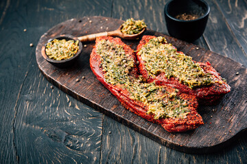 Two raw beef  steaks, marinated with herbs and spices