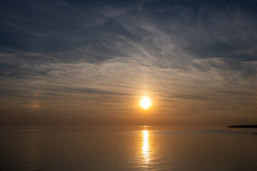 Fototapeta premium Die Nordsee bei Büsum - dramatisch schöner Sonnenuntergang mit Spiegelung auf dem Wasser und dem Watt
