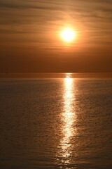 Fototapeta premium Die Nordsee bei Büsum - dramatisch schöner Sonnenuntergang mit Spiegelung auf dem Wasser und dem Watt