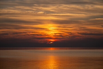 Die Nordsee bei Büsum - dramatisch schöner Sonnenuntergang mit Spiegelung auf dem Wasser und dem Watt