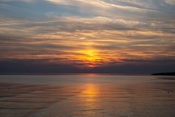 Die Nordsee bei Büsum - dramatisch schöner Sonnenuntergang mit Spiegelung auf dem Wasser und dem Watt