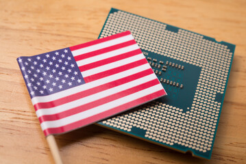 America flag on CPU computer (central processing unit) wooden background. US vs China chip war or...